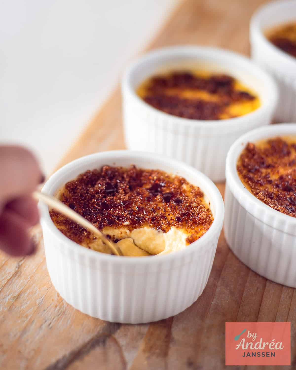 A wooden board with ramekins with cream brulee with honey and cinnamon