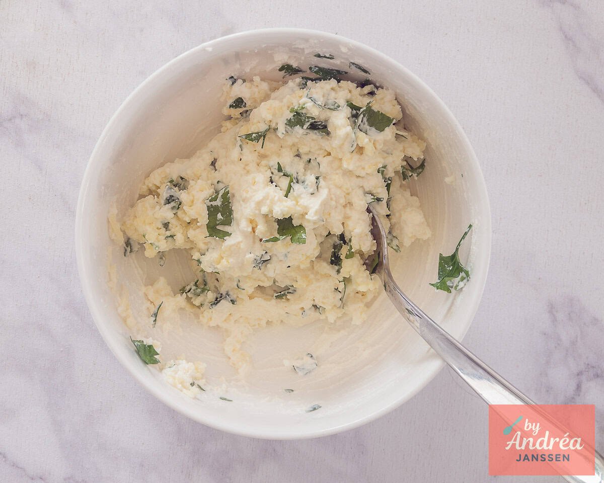 In een kom wordt ricotta met mozzarella en peterselie gemengd.