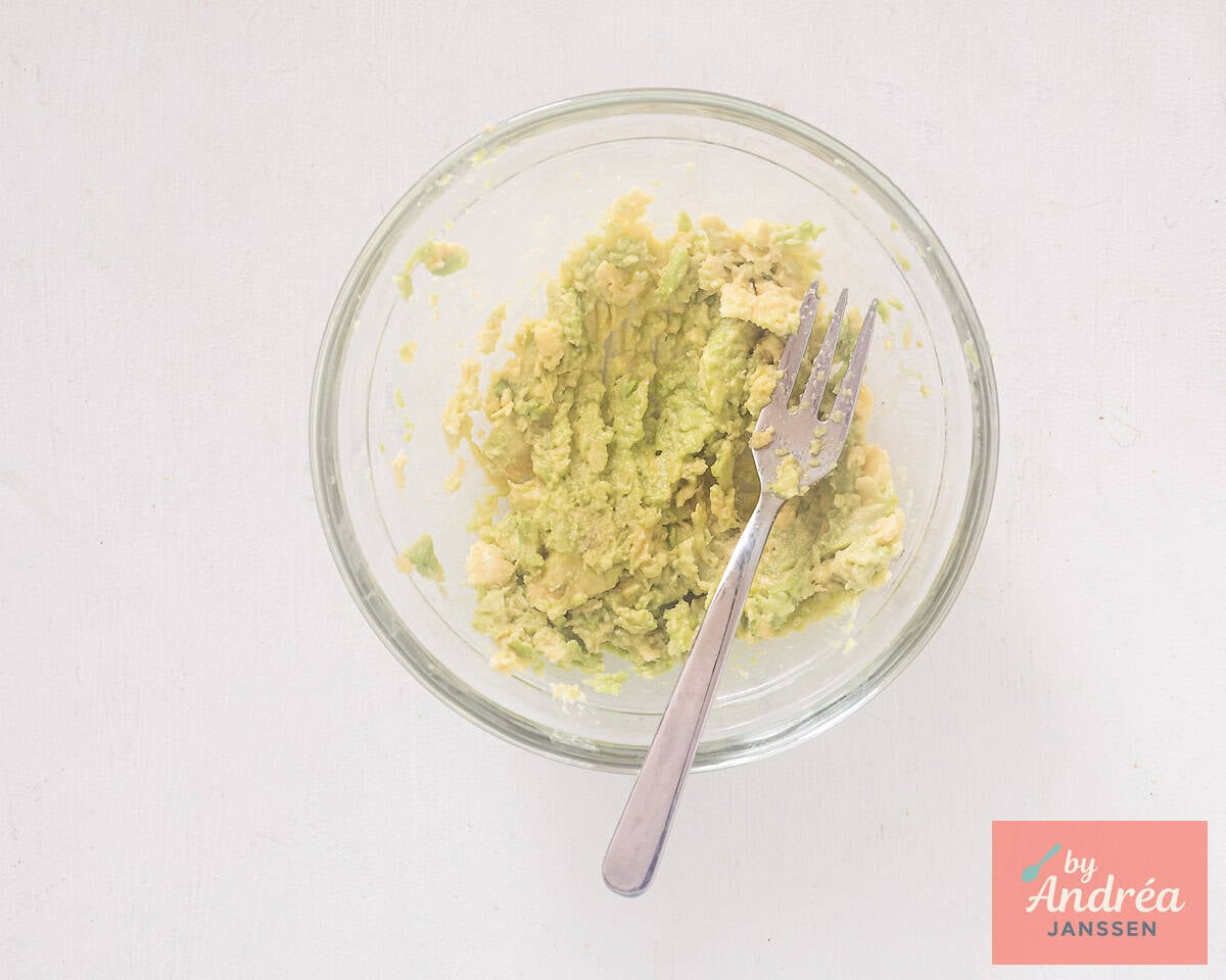 Mashed avocado in a glass bowl
