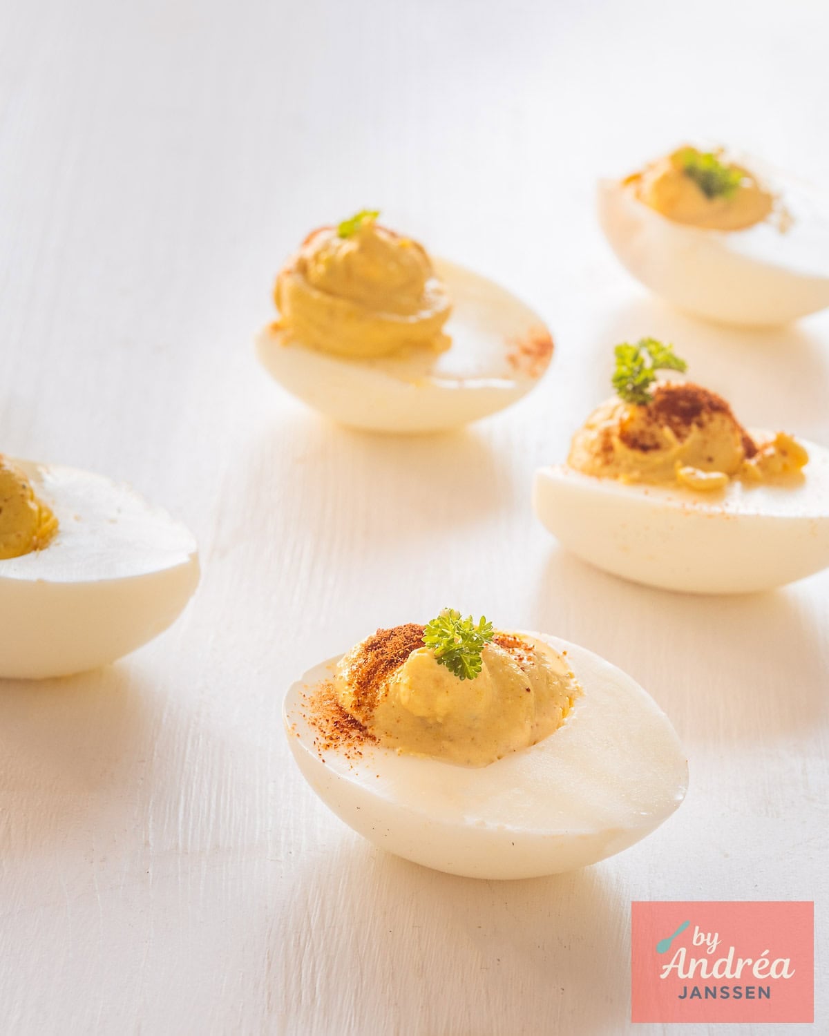 Five curried deviled eggs on a white background