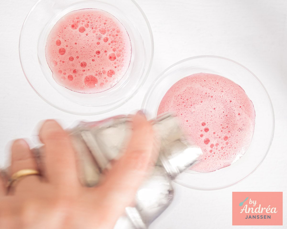 A cocktail shaker with a raspberry cocktail with gin