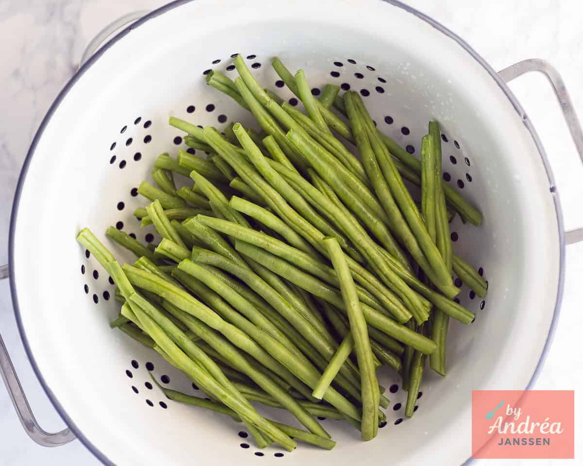 A colander with beans that have been cleaned.