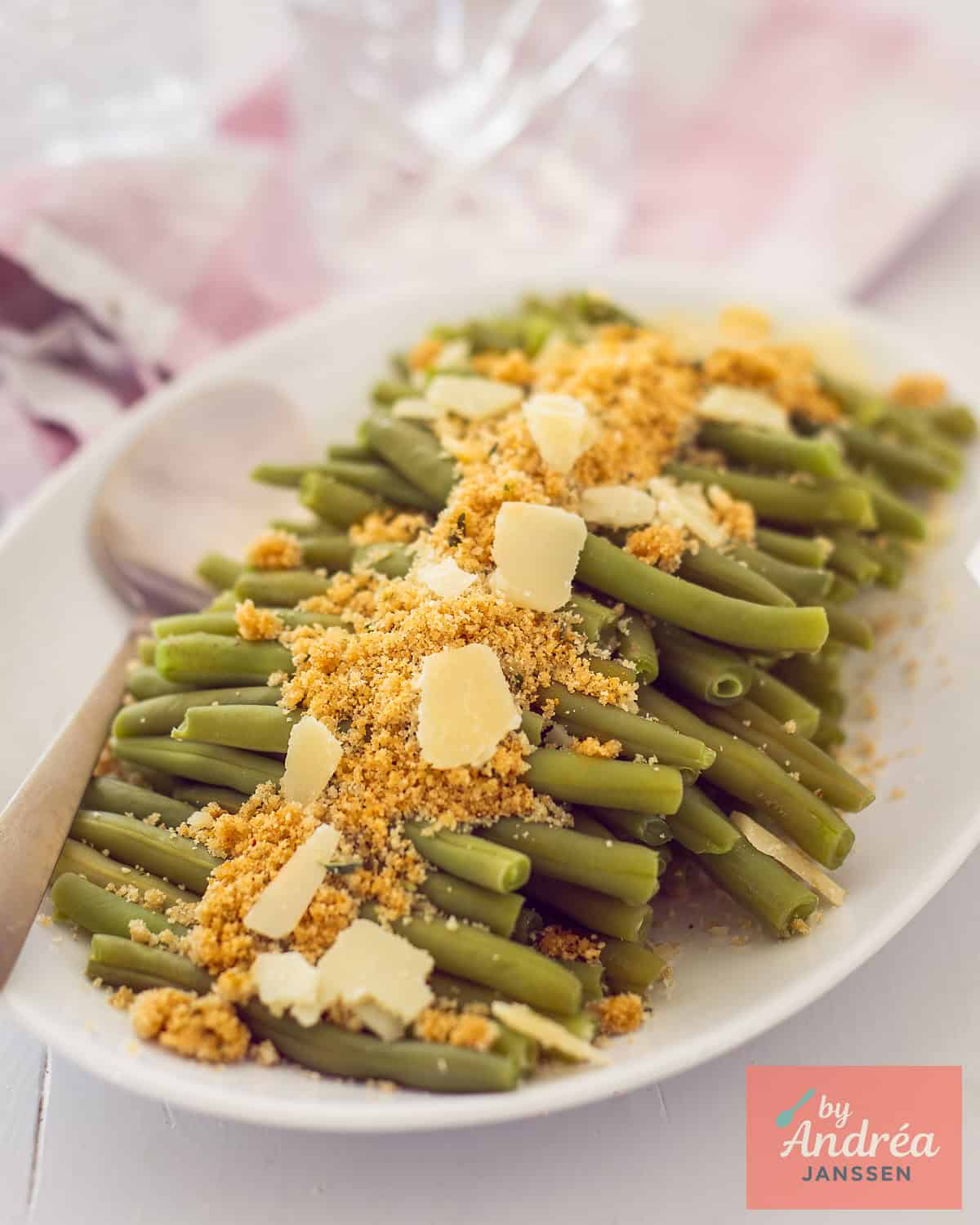 A dish with a thick layer of green beans, Parmesan cheese and a crispy herb layer.