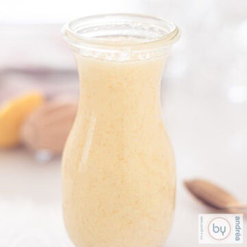 A square photo of a bottle with mayonnaise, made by hand. Some supplies in the background.