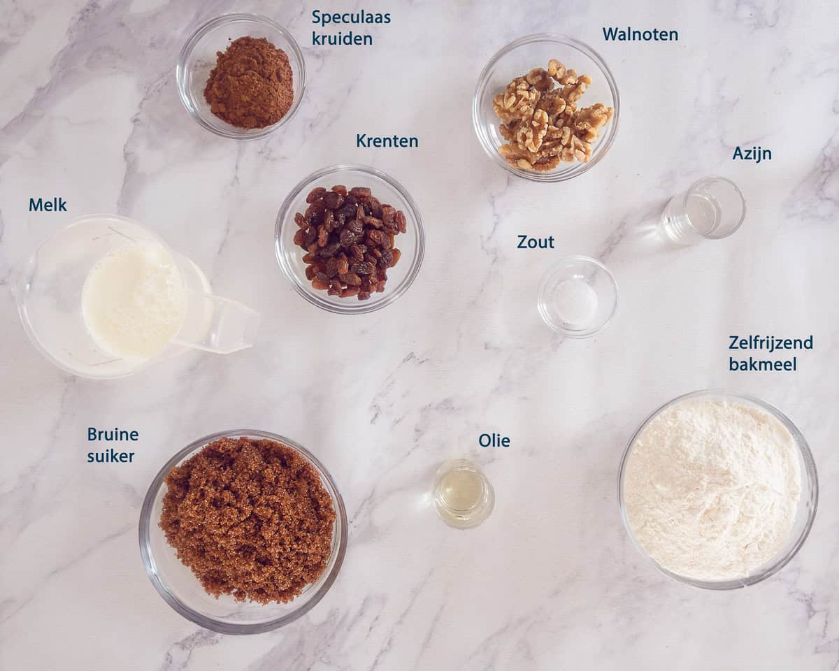 Ingredienten Kruidkoek Met Walnoten En Krenten op een wit gemarmerde ondergrond met tekstbeschrijving