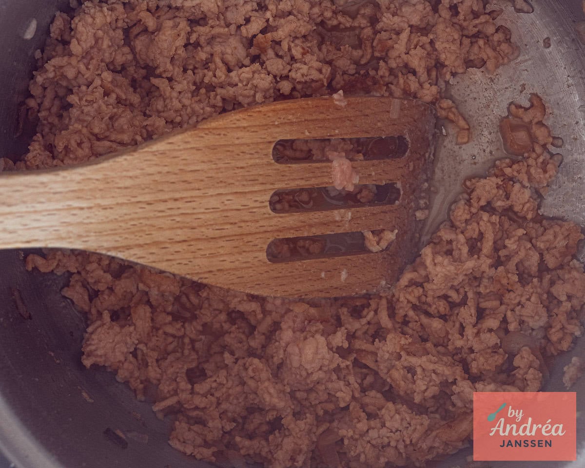 Frying ground chicken.