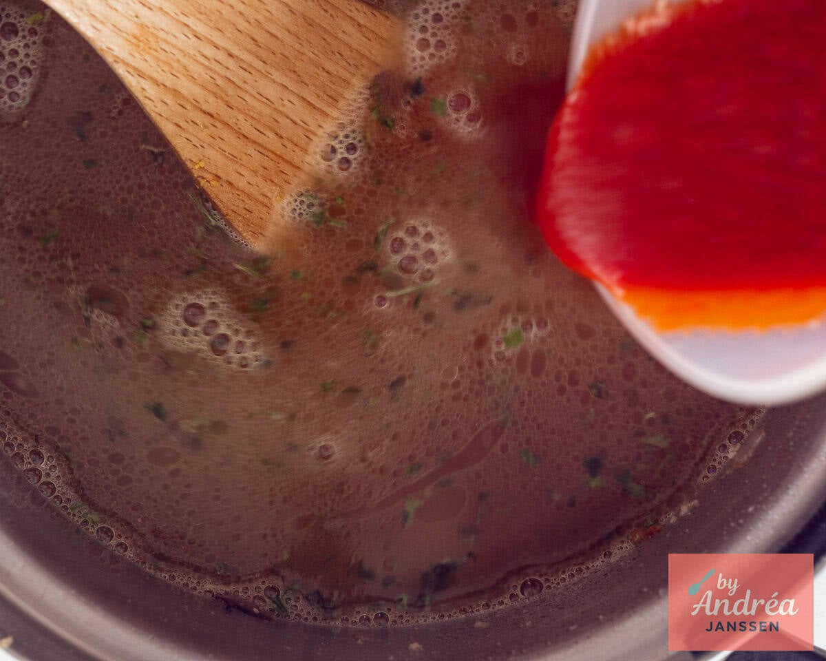 Add stock and sieved tomatoes to the pan.