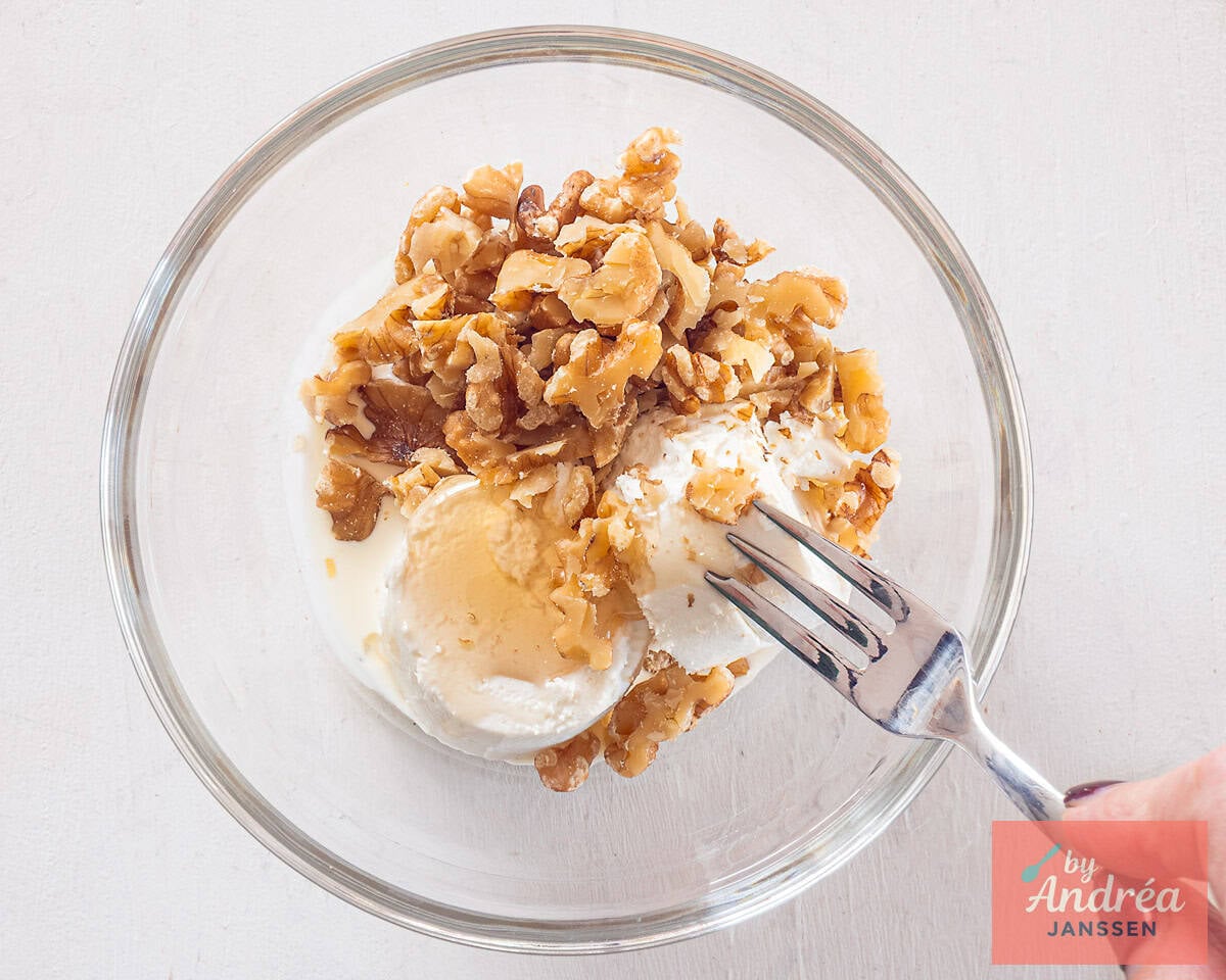 A glass bowl with filling for goat cheese honey and walnut appetizers