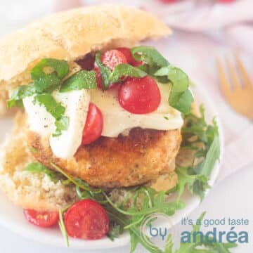 A square photo with an Italian bun, chicken burger, mozzarella, tomatoes and arugula.
