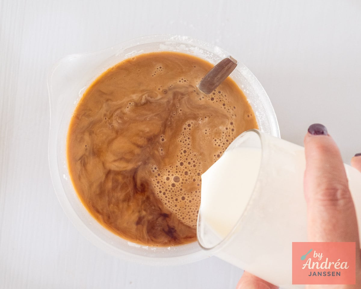 Heavy cream being poured into the sweetened coffee for a creamy iced coffee