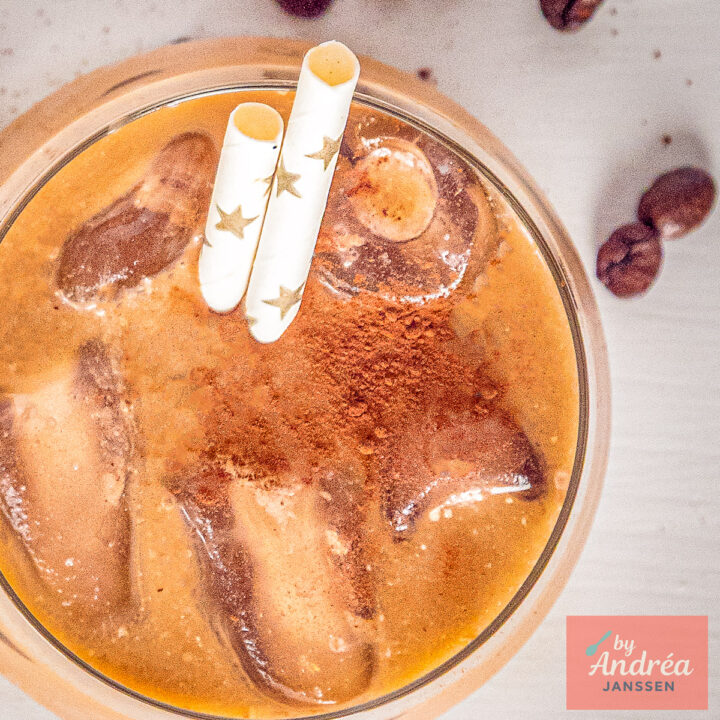 Top-down view of iced coffee with ice cubes and a dusting of cocoa powder