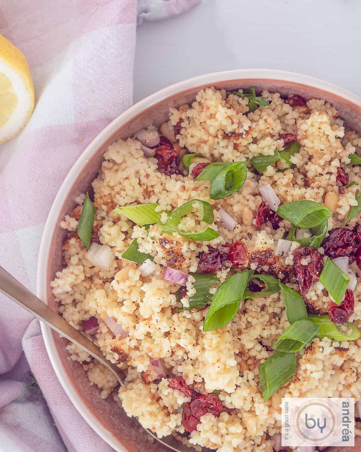 Foto van bovenaf met couscous, cranbery's, peterselie, citroen