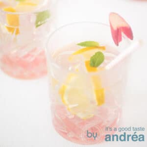 A square photo with two glasses filled with rhubarb iced tea on a white background
