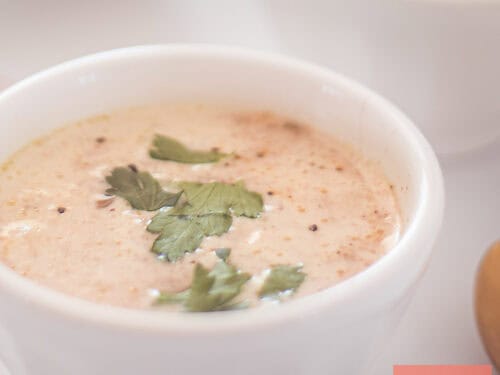 A square photo with a white bowl of fresh radish soup
