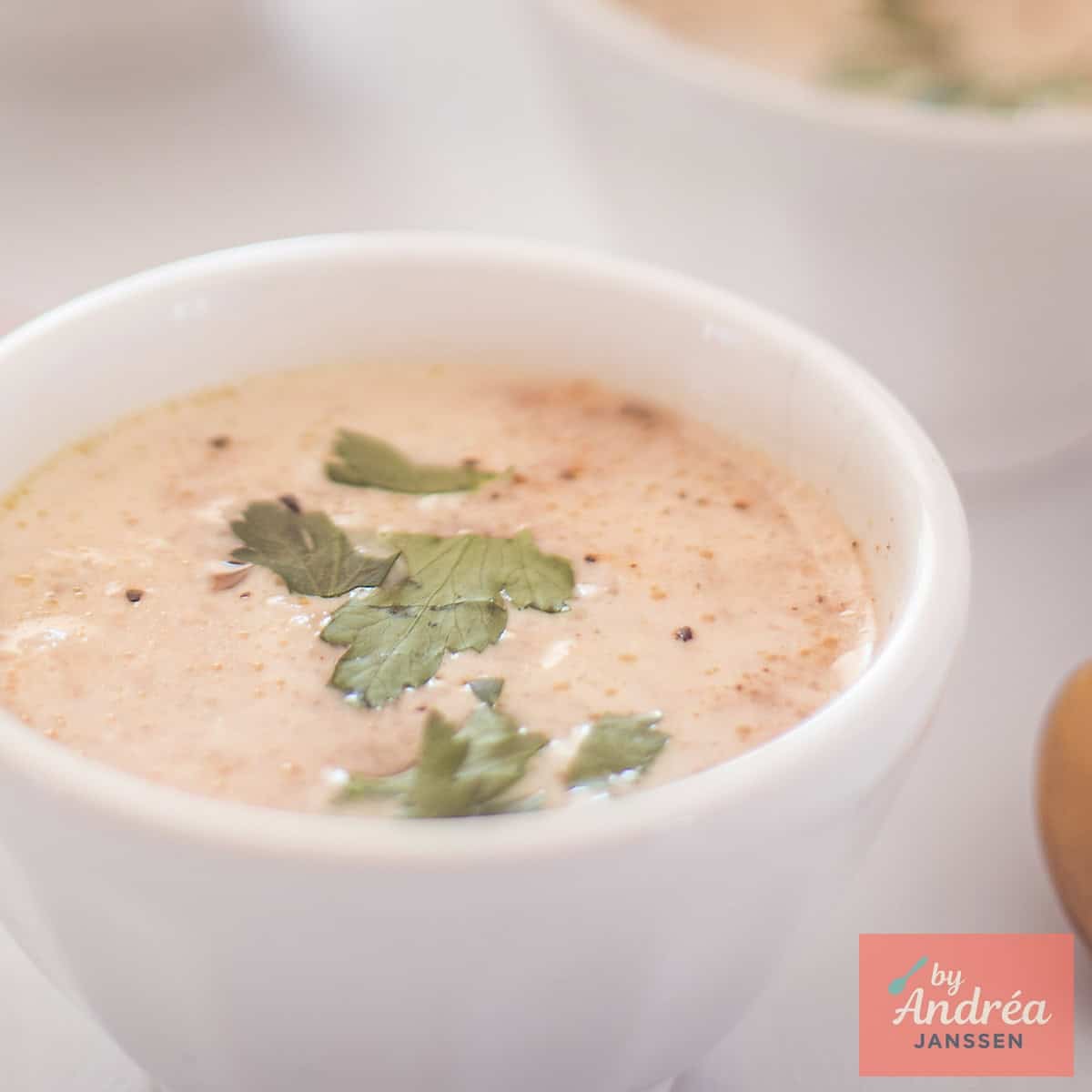 A square photo with a white bowl of fresh radish soup