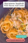 A portion of a gray plate with spaghetti, mascarpone, and leek. A caption reads: Mascarpone Spaghetti With Bacon And Leeks