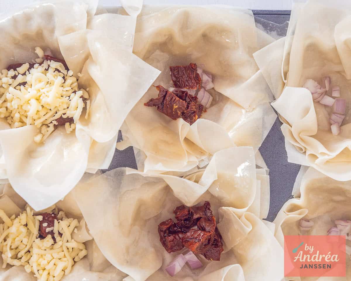 Shallot, sun-dried tomatoes and grated cheese are added to the phyllo dough cups