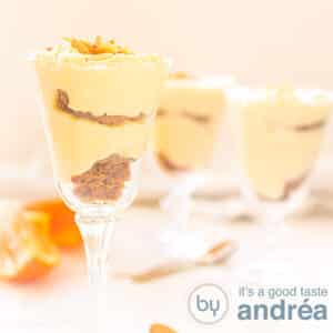 A square photo with three glasses filled with orange and bastogne custard. An orange white background