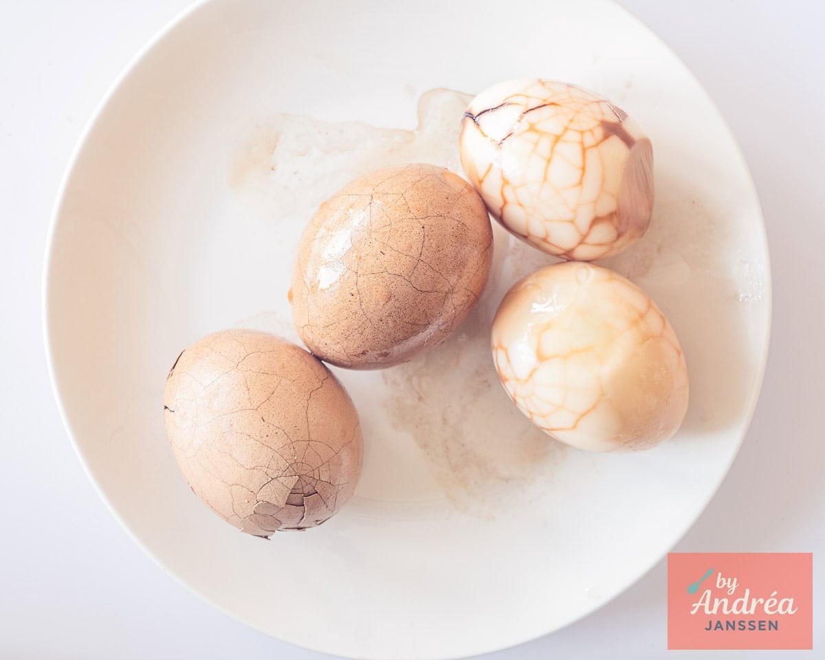 Chinese tea eggs are being peeled, revealing a marbled pattern