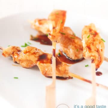 Three yakitori chicken kebab skewers on a white plate.