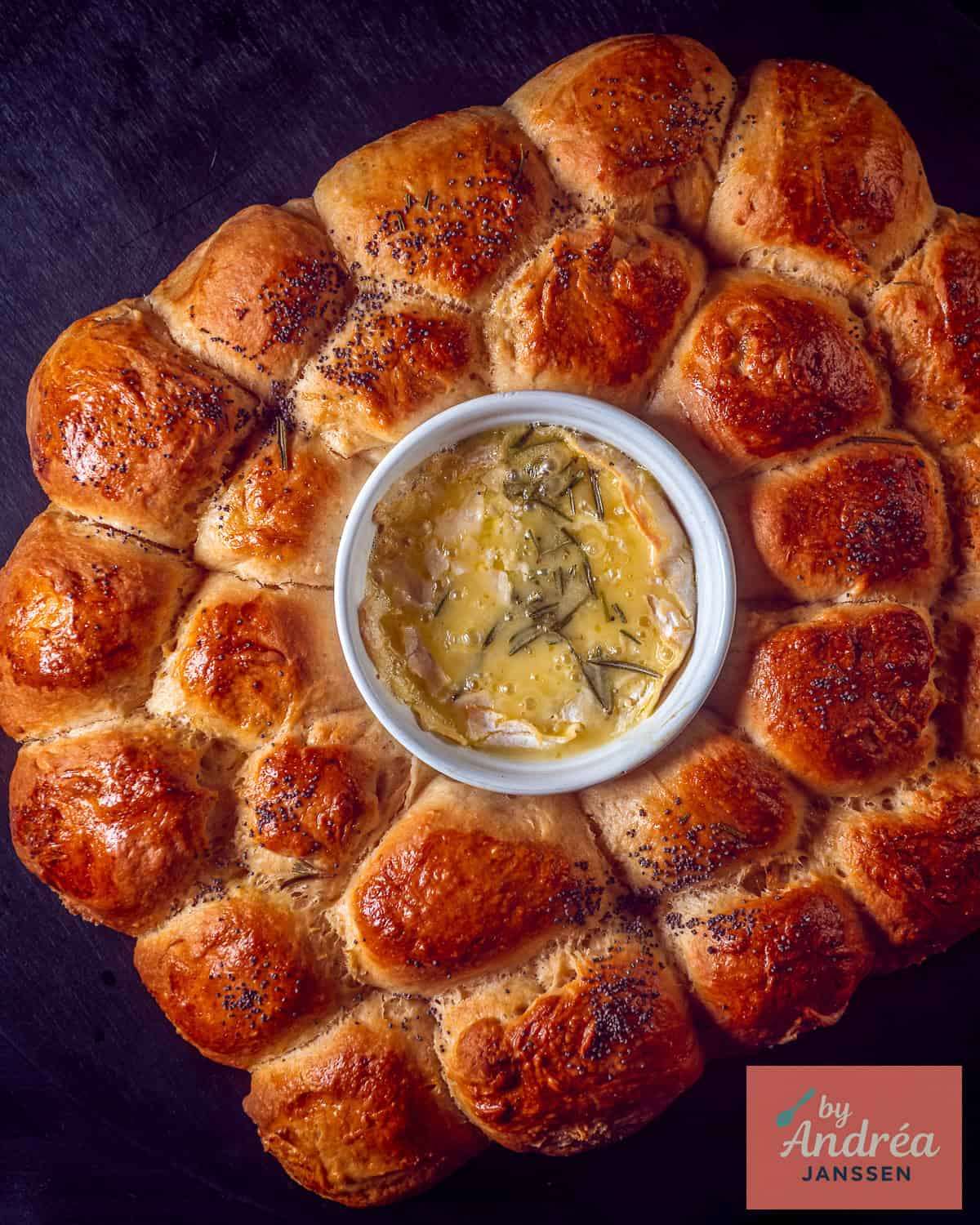 A photo from above of a wreath with homemade garlic balls and melted Camembert in the middle.