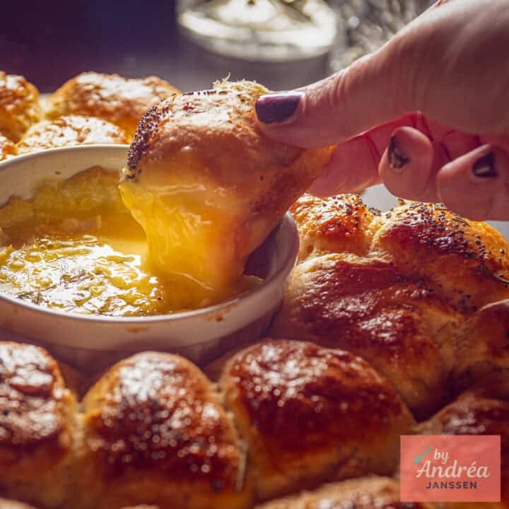 A roll of garlic bread dipped in melted camembert.