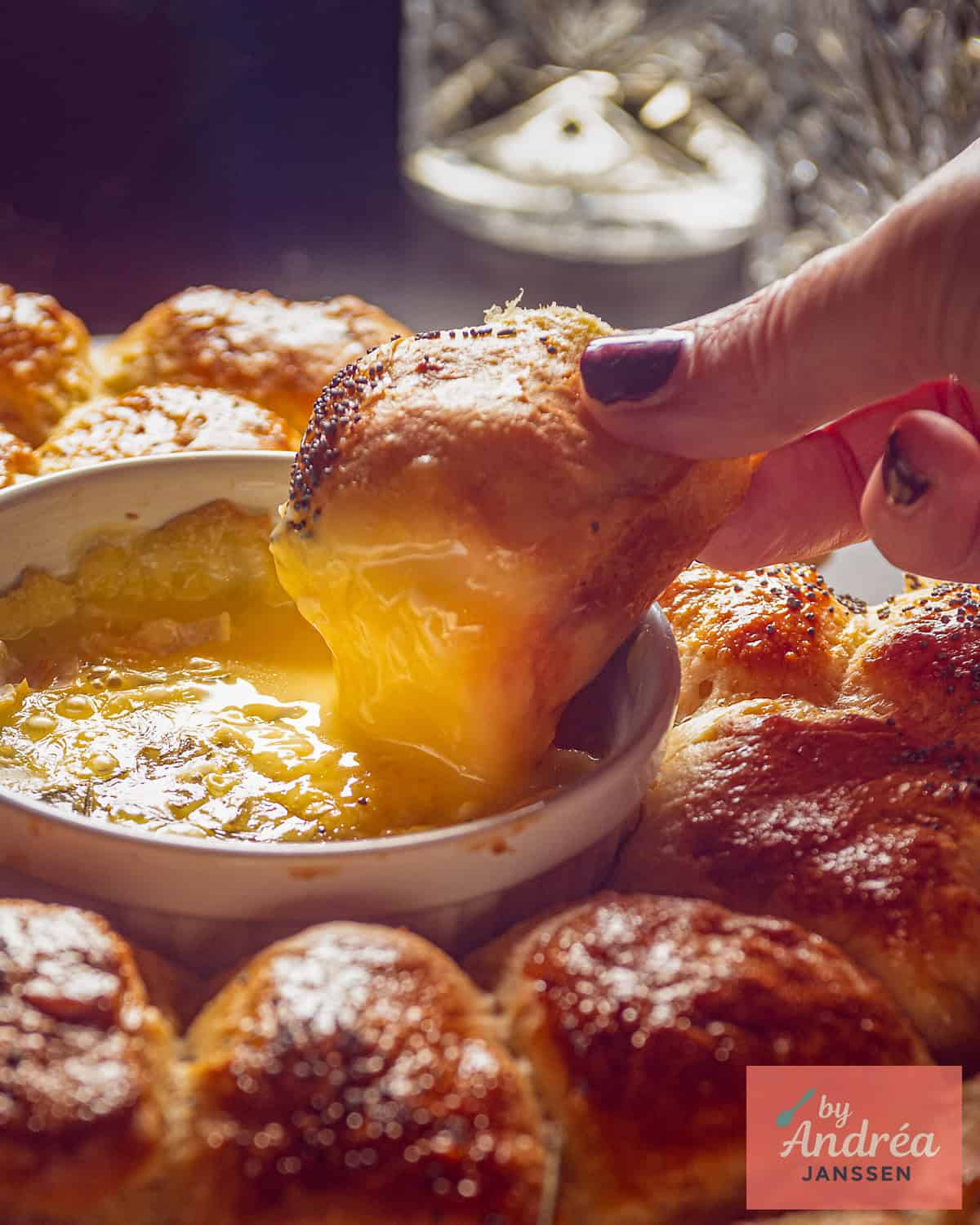 A garlic roll dipped in melted Camembert, with a wreath of rolls around it.