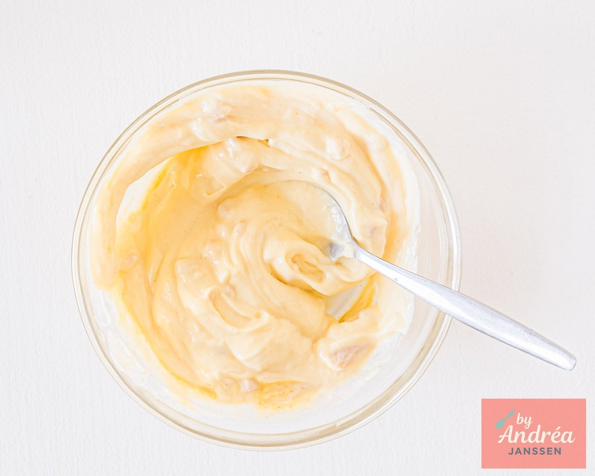 Mixing homemade aioli in a glass bowl