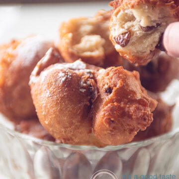 a glass bowl filled with Dutch donuts. One is opened so you can see the airy texture