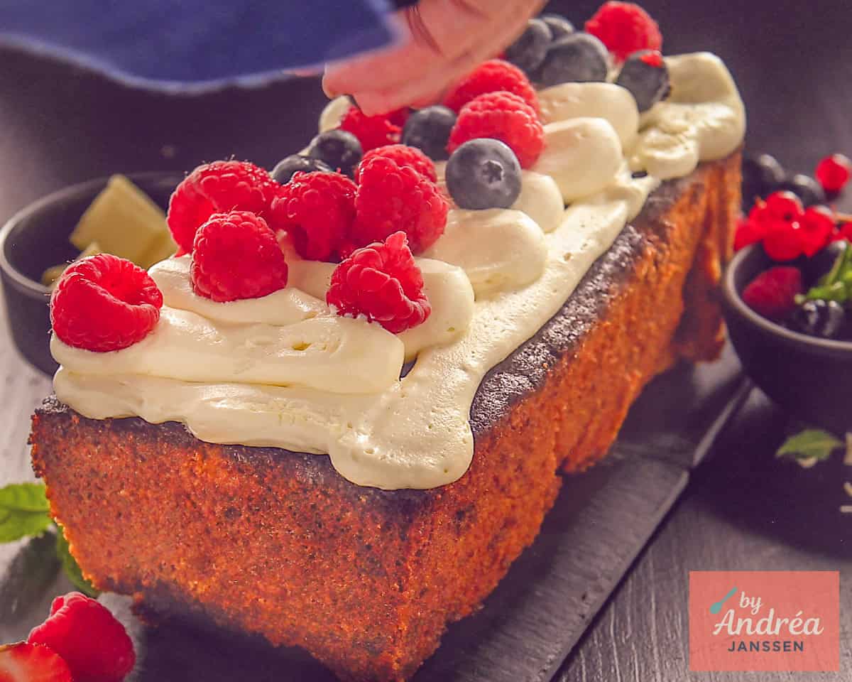 Decorating white chocolate cake with buttercream and fresh fruit