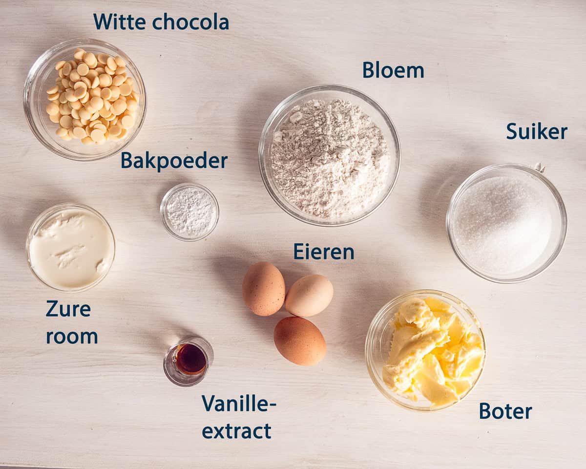 ingredienten Witte Chocolade Cake op een beige ondergrond met tekstbeschrijving.