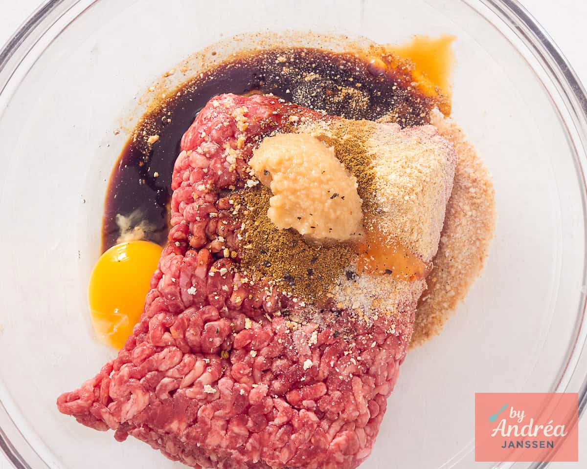 A bowl with ground beef and flavorings.