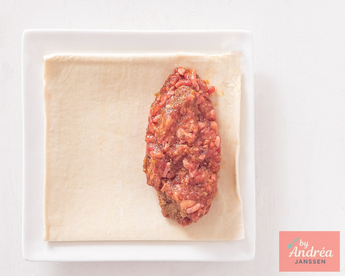 A roll of ground beef on a puff pastry sheet