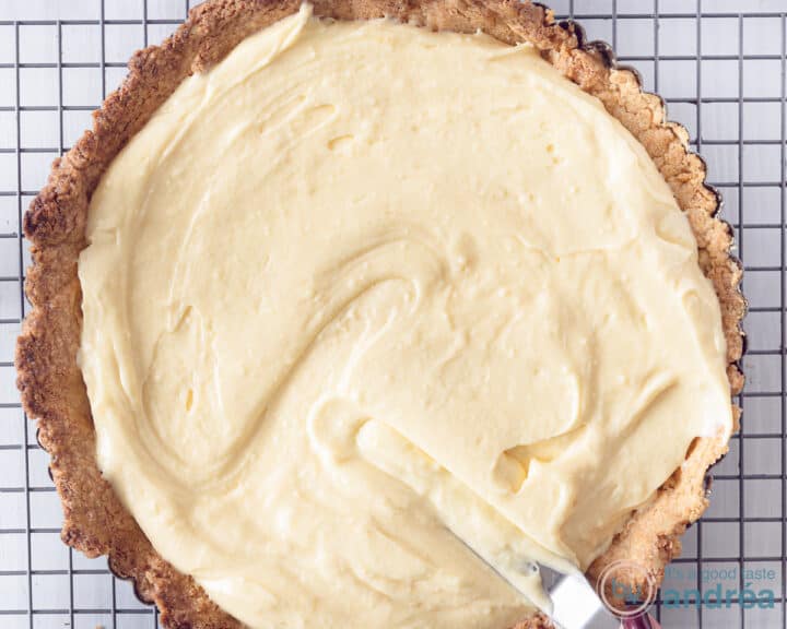 Pie dough filled with pastry cream that is smoothed with a palette knife