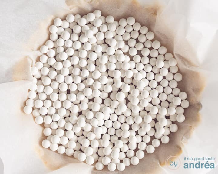 Dough in which baking paper with baked peas has been placed.