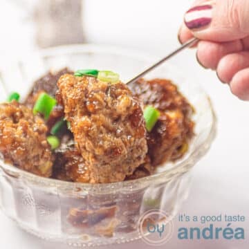 Square photo of a glass dish filled with teriyaki meatballs with sauce and sprinkled with spring onions