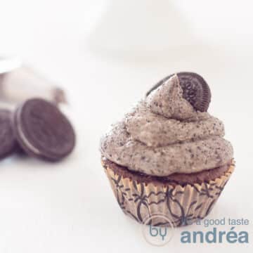 A square photo with an Oreo cupcake in the front right. Left behind Oreo cookies. A white background.