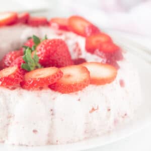 A square photo with part of a bavarian with strawberries garnished with strawberry slices
