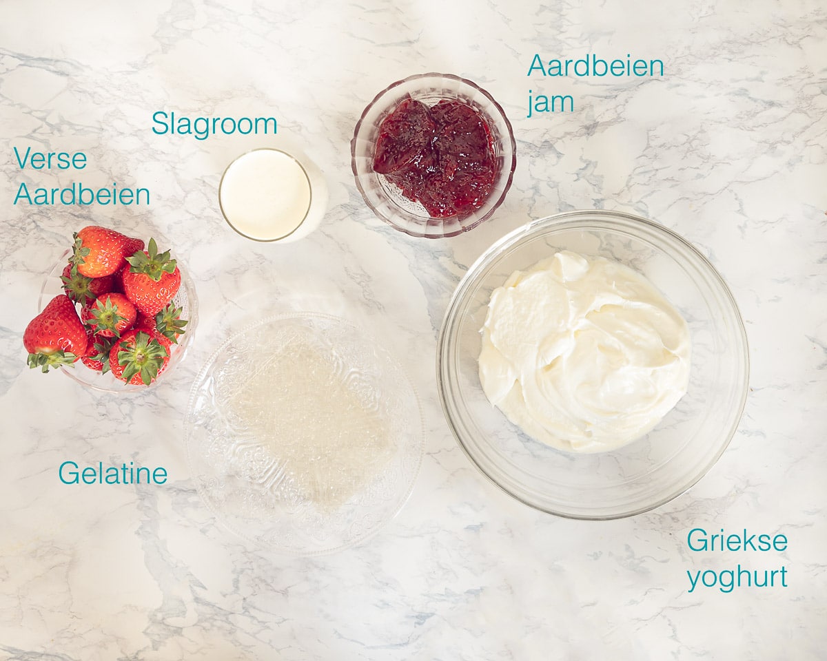 Ingrediënten Verse Aardbeien Bavarois met Griekse Yoghurt op een gemarmerde ondergrond met tekst overlay