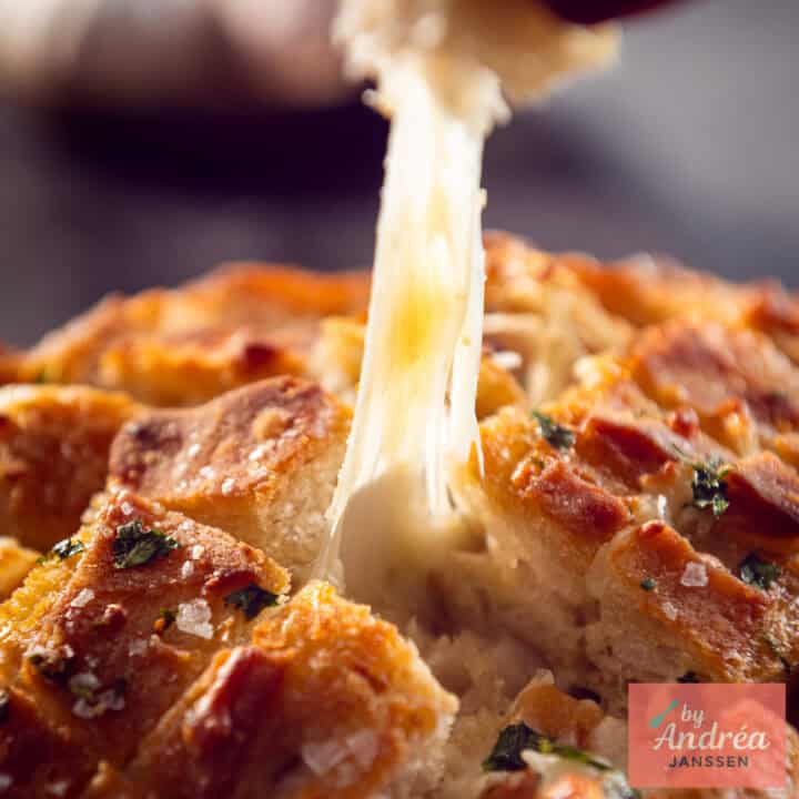 Cheesy garlic pull-apart loaf with diamond cuts, parsley and Maldon salt on top