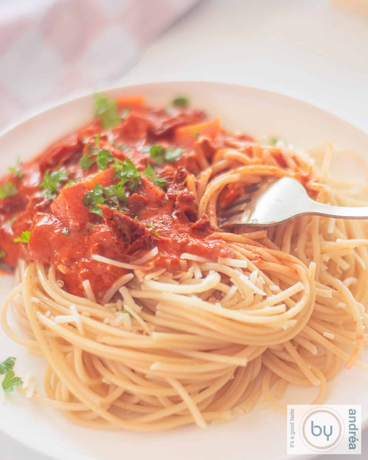 A photo of a white plate with a mountain of spaghetti with tomato sauce, minced meat and mascarpone