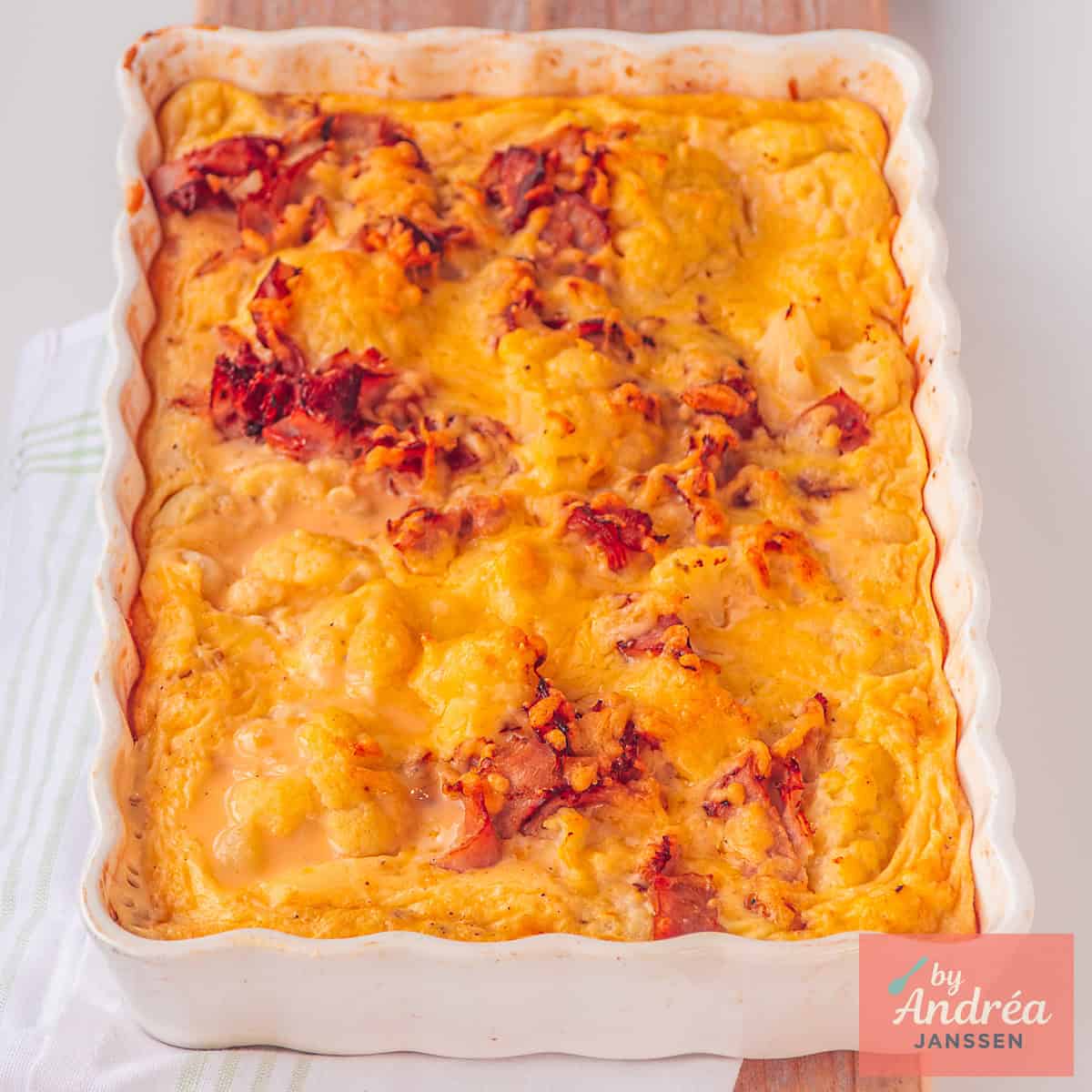 A square photo of an oven dish with cauliflower au gratin with bacon.