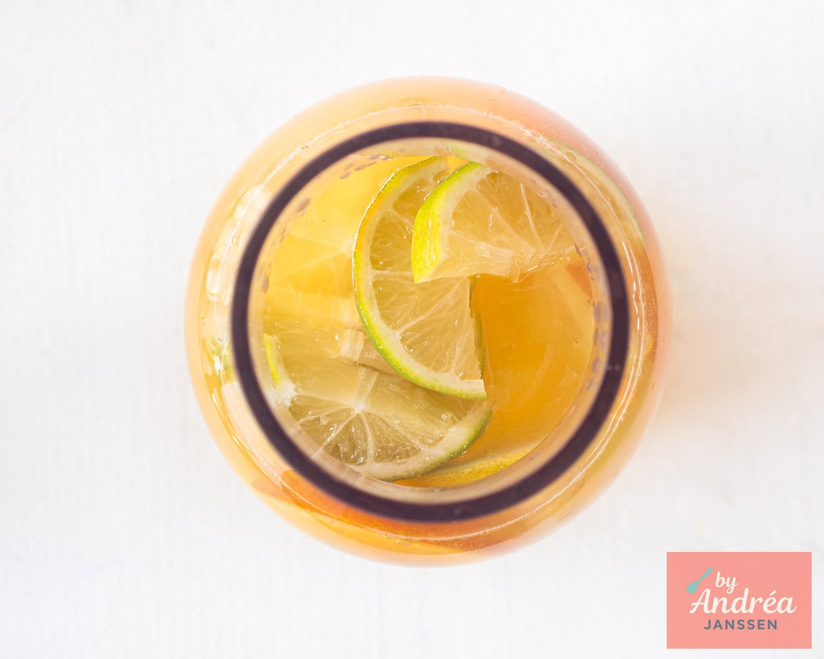 Iced tea topped with ice cubes and slices of fresh citrus fruit.