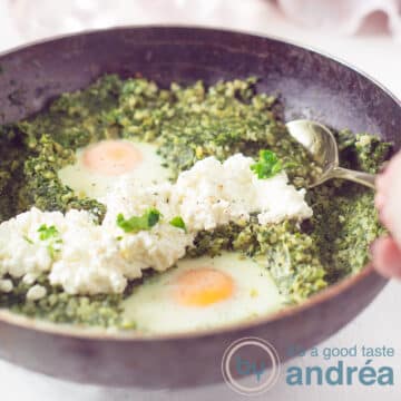 A square photo with a black pan filled with a cauliflower rice, leek and spinach dish with egg and cottage cheese.