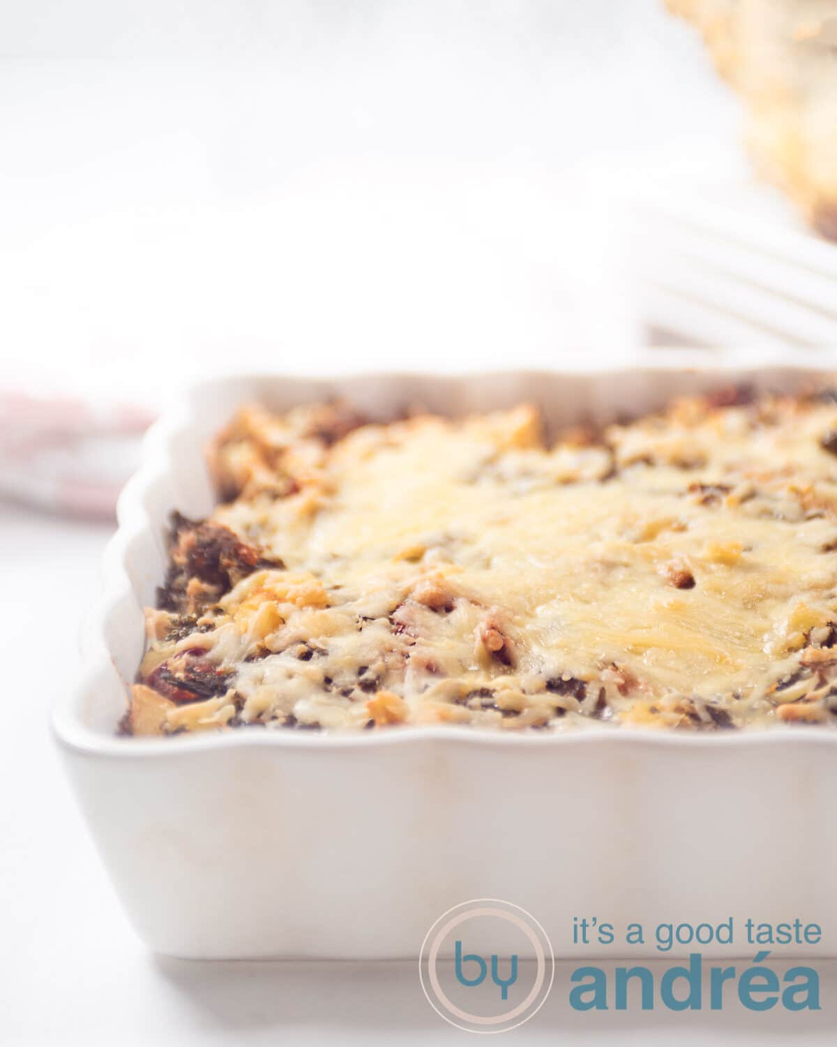 a white casserole dish filled with a kale potato gratin