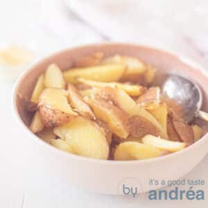 A square photo with a pink dish with oven chips on it. A white background.