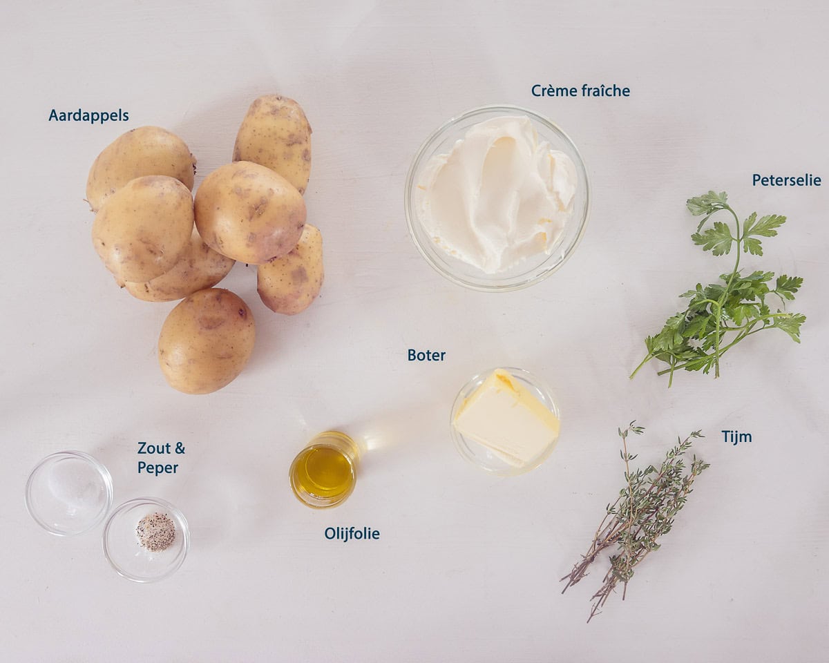 Ingredienten Hasselback Aardappelen Met Tijm En Boter op een witte ondergrond met tekstbeschrijving