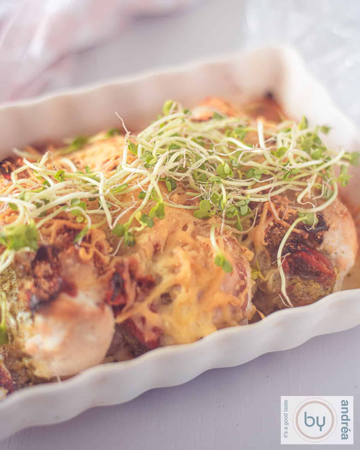 A casserole with chicken fillet with pesto and cheese.