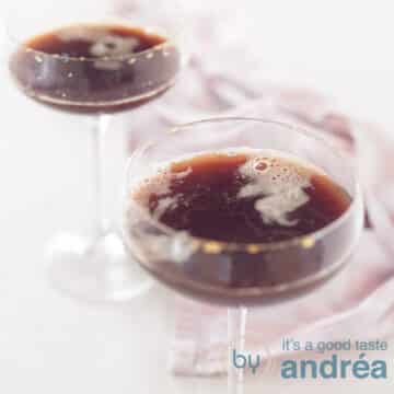 A square photo with two champagne flutes filled with a cold-brew coffee liqueur. A pink white tea towel in the background