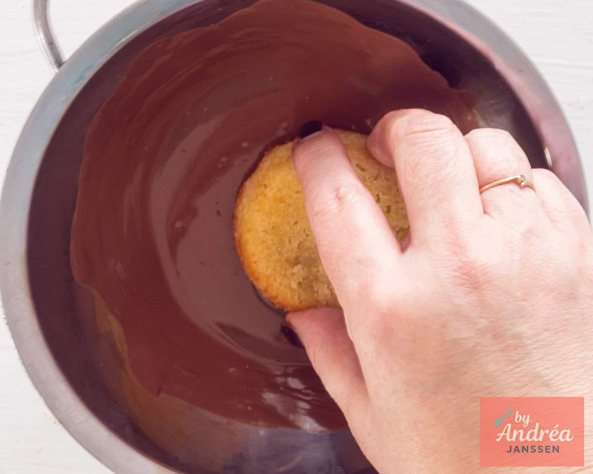 The cupcake is dipped in melted chocolate